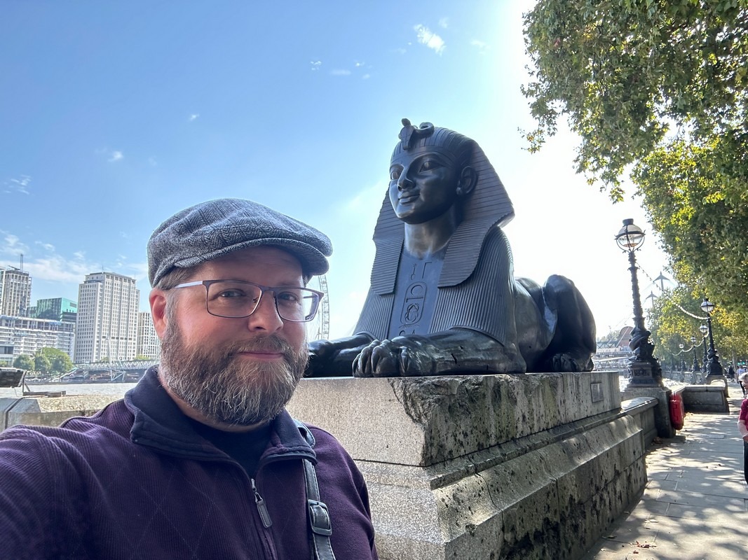 Nate Loper beside a bronze sphinx at Cleopatra’s Needle on the Victoria Embankment in London
