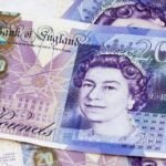 A close-up of British twenty pound banknotes, featuring a portrait of Queen Elizabeth II and architectural designs, with overlapping notes in the background—perfect for planning your next adventure eating in London.